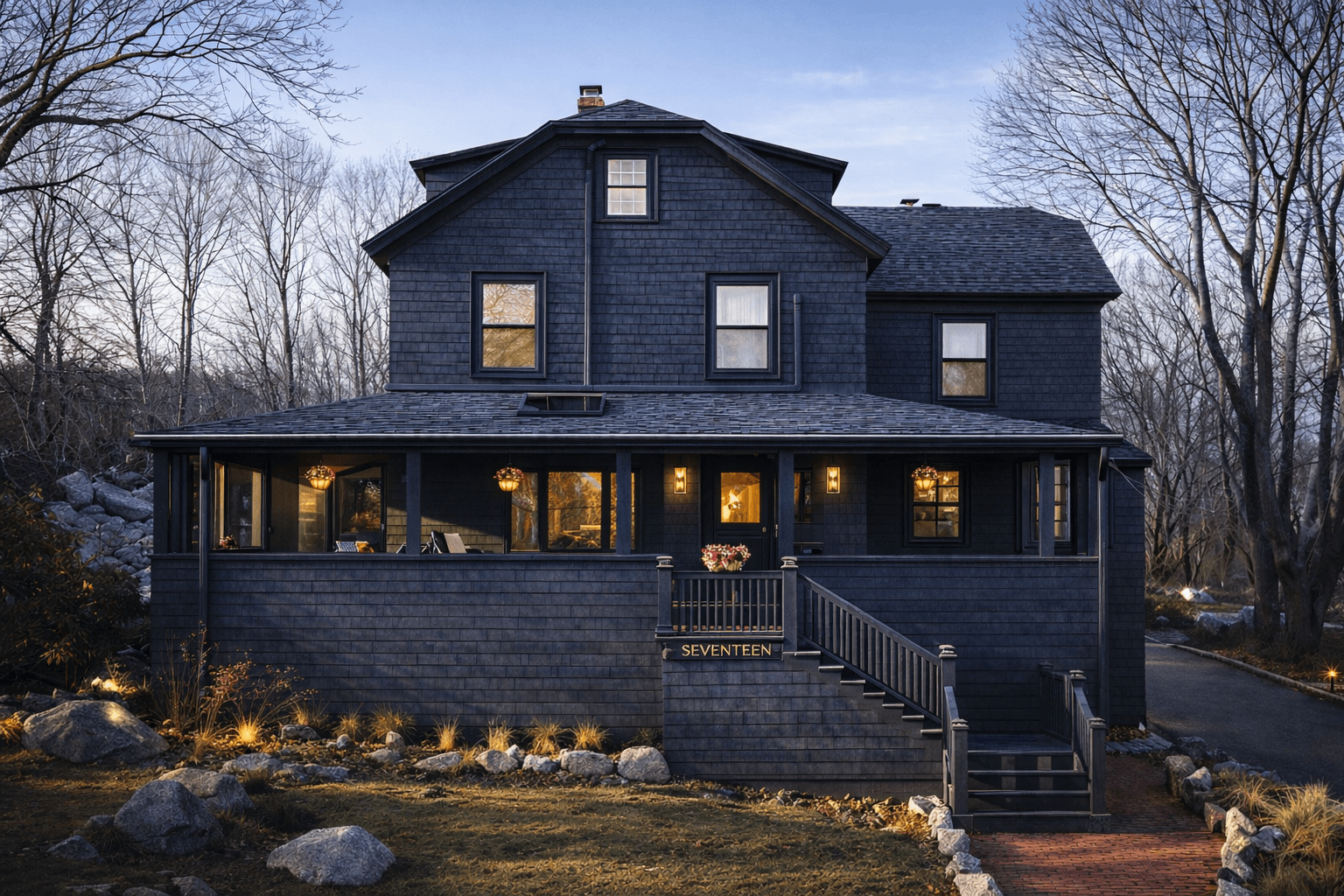 The Good Harbor Beach home with its porch lights on at dusk