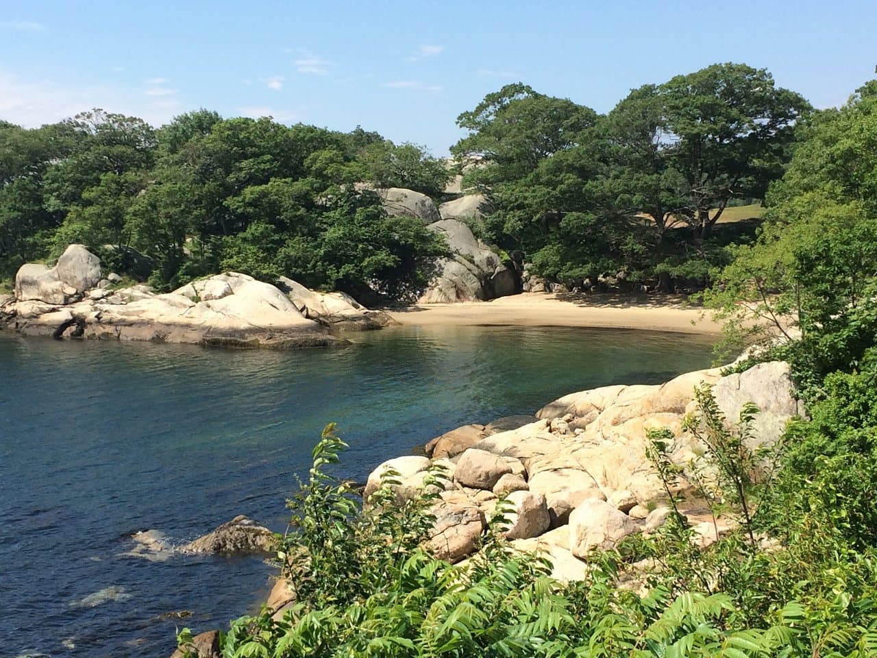 Tucked-away Half Moon Beach in summer, granite ledges and quiet water